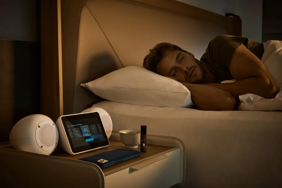 A guest sleeps beside the SleepHub speakers and a sleep balm in a room at COMO Metropolitan Singapore