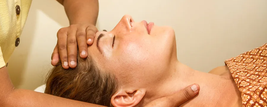 A guest receives a calm head massage at Kamalaya Wellness Sanctuary